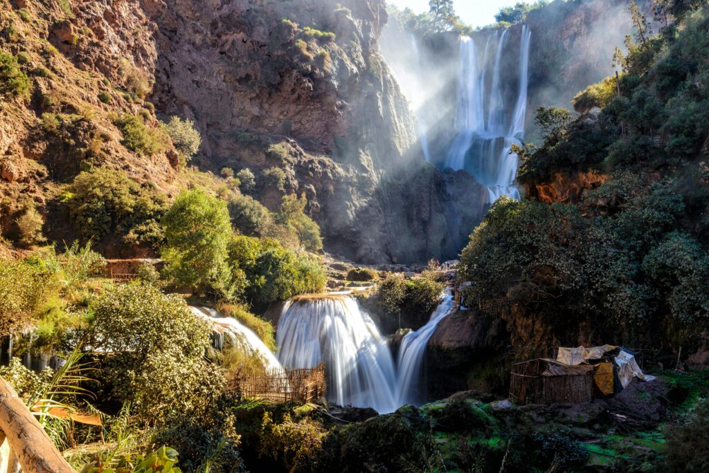 Stunning multi-tiered waterfalls cascading through mossy rocks in a lush forest setting under daylight.